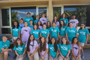 A group of teens pose for a photo with matching t-shirts.