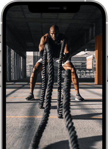Intense indoor workout with battle ropes in a modern gym setting.