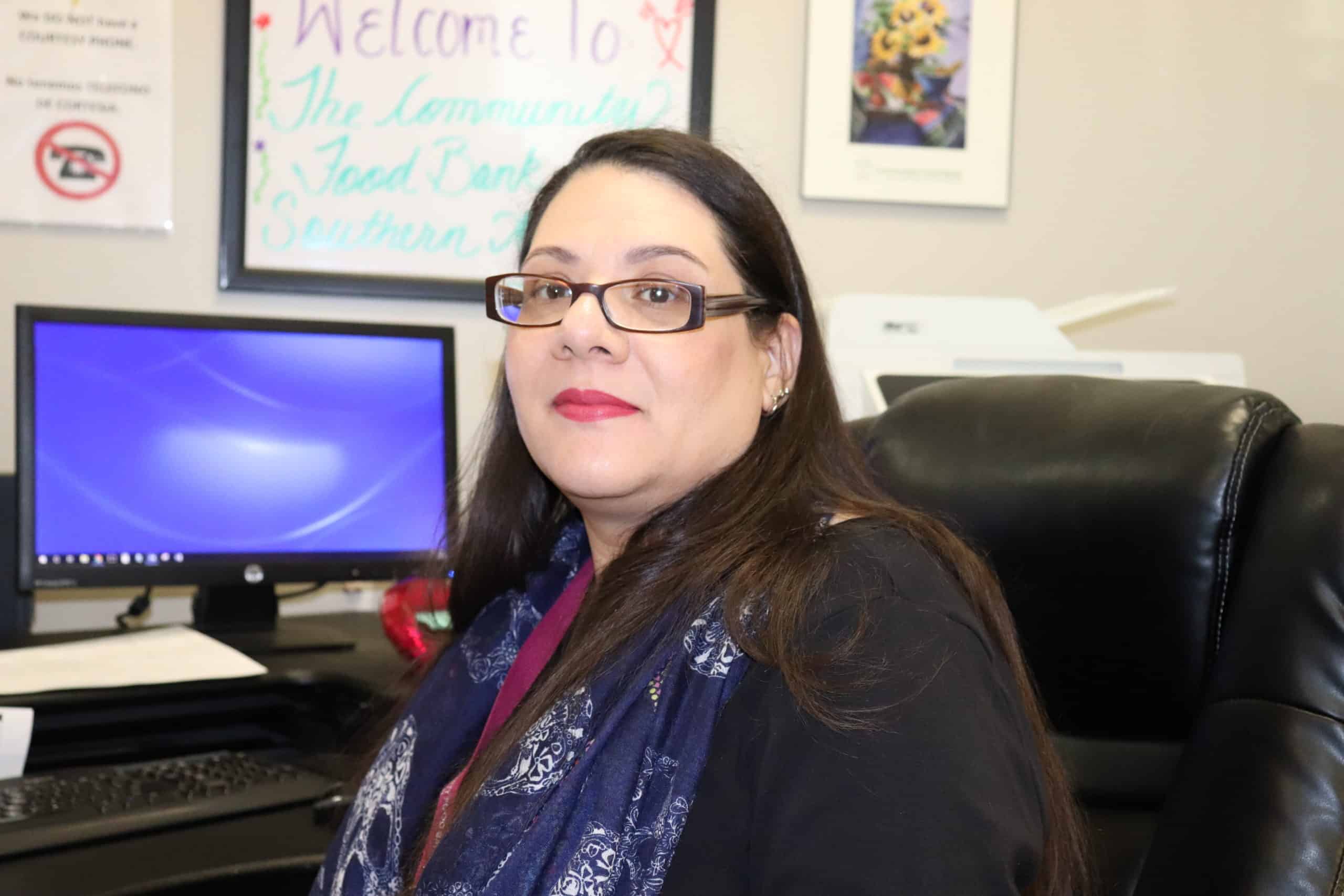 Volunteer management professional working at a desk with a computer in an office setting.