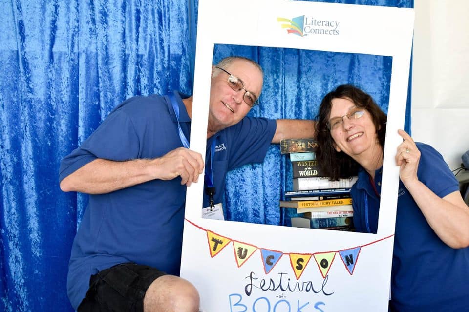Volunteer management association photo with people reading books at literacy event.