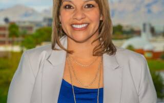Compassionate woman smiling with mountains and cityscape background, promoting volunteer management.