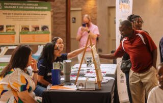 a volunteer booth with people discussing volunteer opportunities